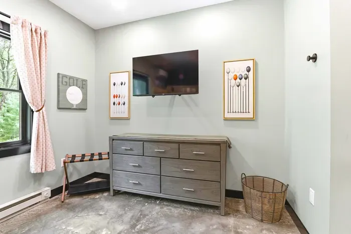 Add a little downtime to your stay with a cozy golf-themed room featuring a wall-mounted TV, thoughtful storage, and peaceful treetop light.