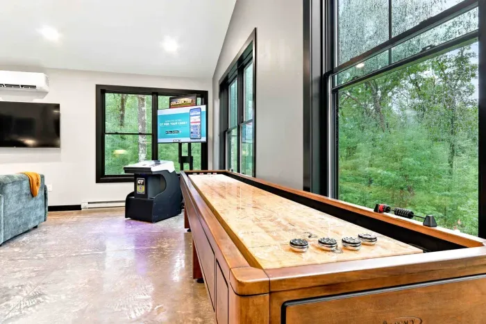 Enjoy a bright game room with shuffleboard, arcade fun, and peaceful wooded views all around.