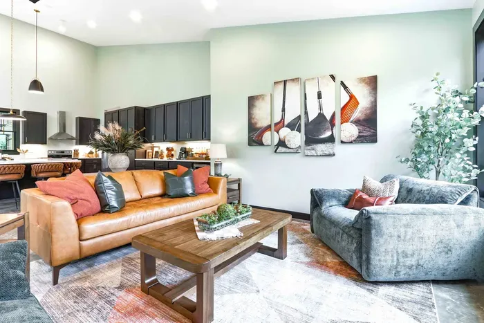 Settle into a warm, stylish lounge where cozy seating, thoughtful design, and an open kitchen create an inviting space to relax and reconnect.