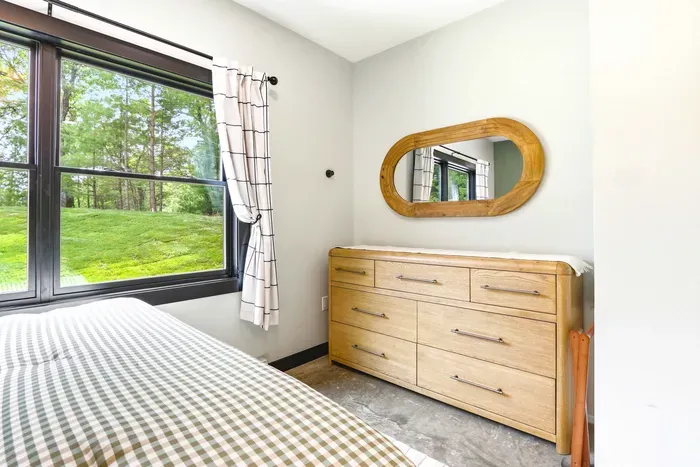 Settle into a calm bedroom corner with warm wood details, generous storage, and peaceful green views that make mornings feel easy.
