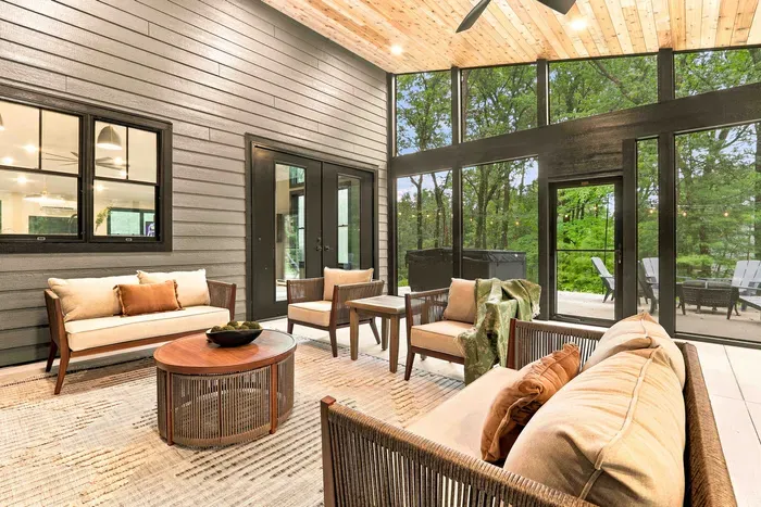 Relax in the screened-in patio with cozy seating and peaceful wooded views just steps from the outdoor patio.