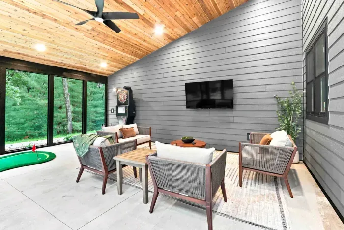 Enjoy a screened-in patio with a TV, dartboard, and indoor putting green for relaxed fun with wooded views.