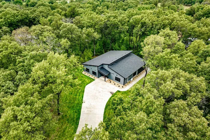 Arrive at a modern wooded retreat with a spacious driveway and peaceful privacy all around.