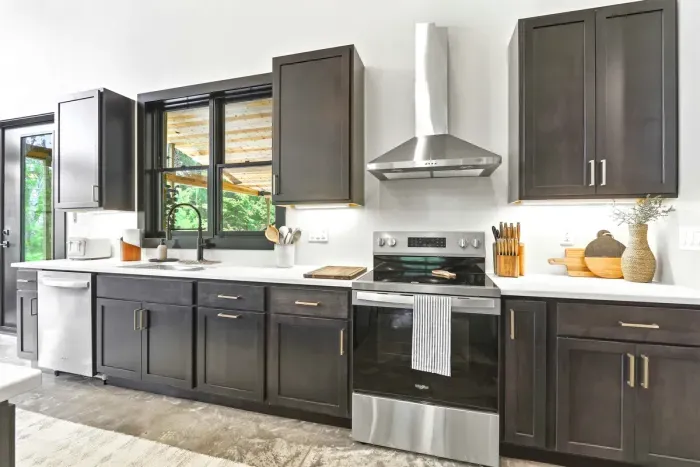 Cook with ease in a sleek, light-filled kitchen where modern finishes, thoughtful tools, and wooded views make every meal feel effortless.