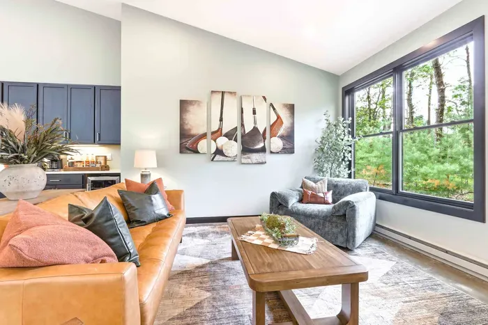 Relax into a sunlit lounge with warm textures, cozy seating, and treetop views that make unwinding feel effortless.