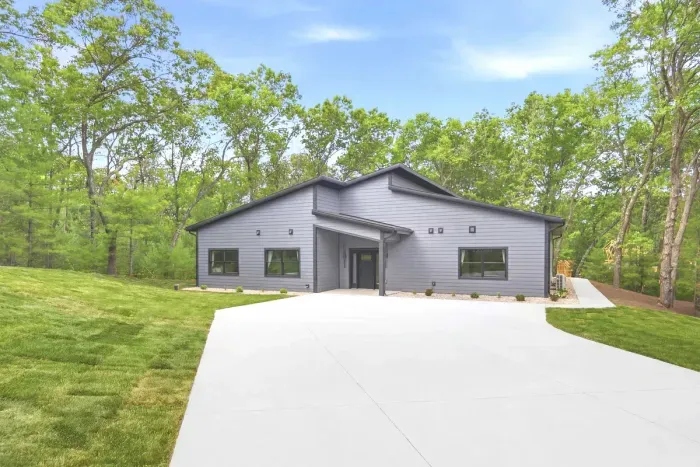 Arrive to a sleek modern retreat tucked among the trees, where a spacious drive and peaceful setting set the tone for an effortless getaway.