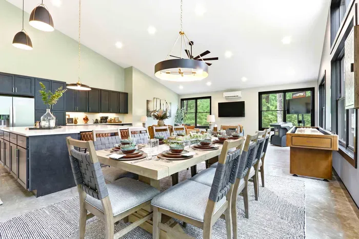 Share memorable meals in a bright, open gathering space where the dining table, kitchen, and game area come together for effortless connection.