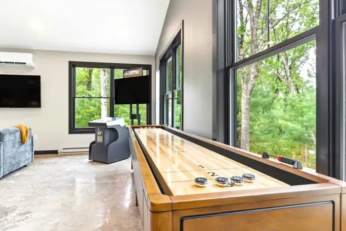 Bring the fun indoors with a bright game room featuring shuffleboard, arcade-style entertainment, and treetop views that make every hangout feel like a getaway.