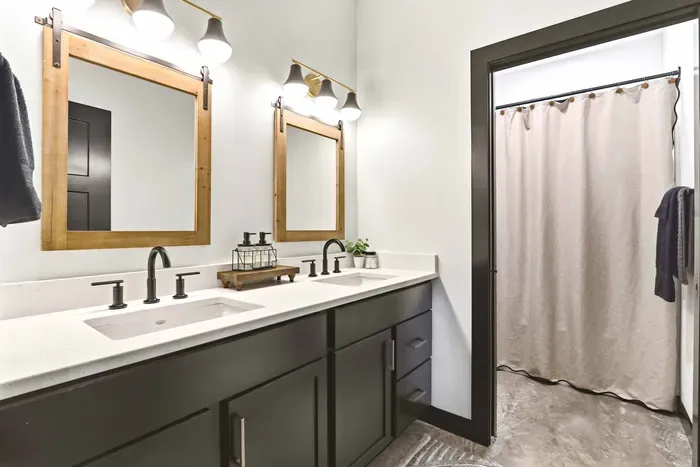 Refresh with ease in a modern dual-vanity bath, where warm wood accents, sleek finishes, and shared space make mornings feel smooth and effortless.