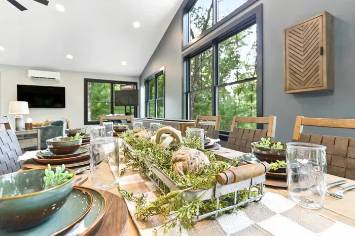 Share slow meals and easy conversation at a beautifully set table, framed by soaring windows, treetop views, and a bright space made for gathering.