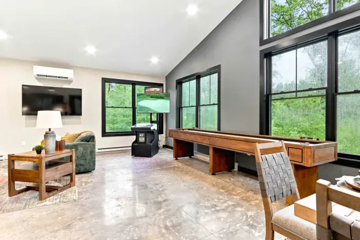 Enjoy game-room fun with shuffleboard, Golden Tee golf, and a TV lounge framed by wooded views.