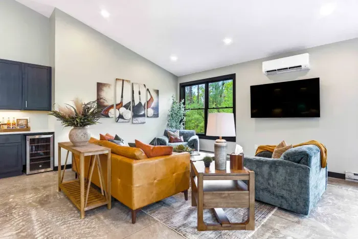 Unwind in a cozy lounge with warm textures, treetop views, and a big-screen setup made for relaxed movie nights and easy conversation.