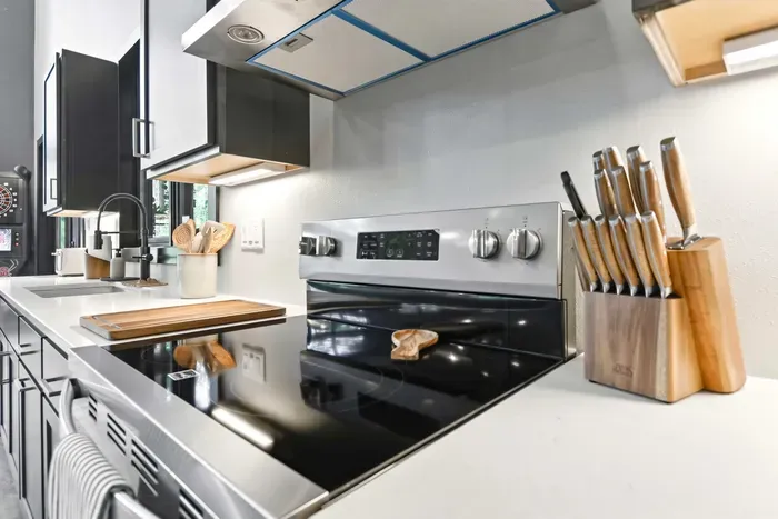 Cook with confidence in a sleek, well-stocked kitchen where modern appliances, quality tools, and bright prep space make meals feel effortless.