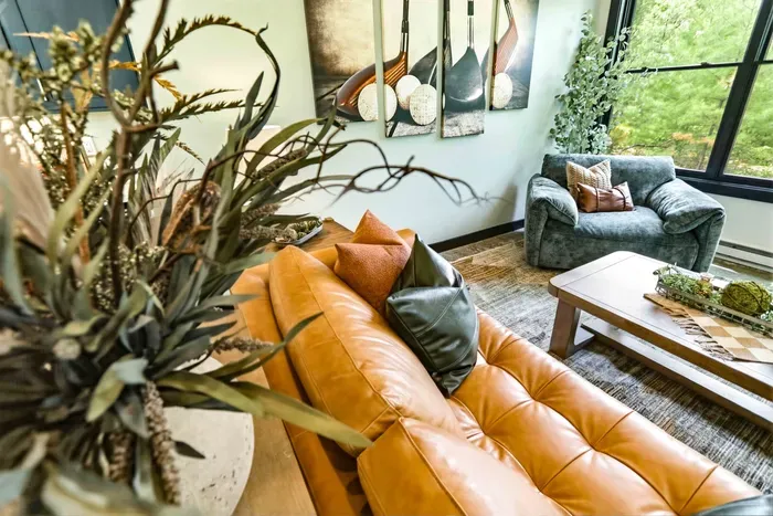 Relax into a beautifully layered lounge with warm leather seating, soft textures, and peaceful treetop views that make downtime feel effortless.