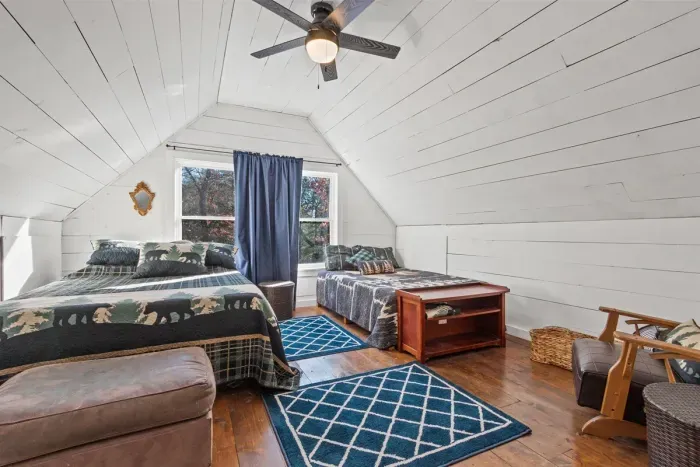 A cozy loft featuring two comfortable beds, perfect for friends or family seeking a private, relaxed sleeping space.