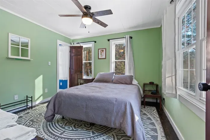 A fresh and calming bedroom with soft gray sheets set against mint green walls, creating a soothing and inviting retreat.