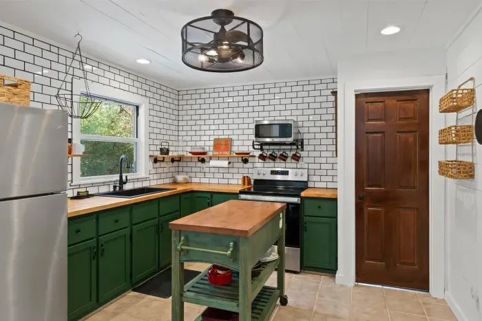 A bright kitchen featuring green lower cabinets, adding a pop of color and a fresh, modern touch to the space.