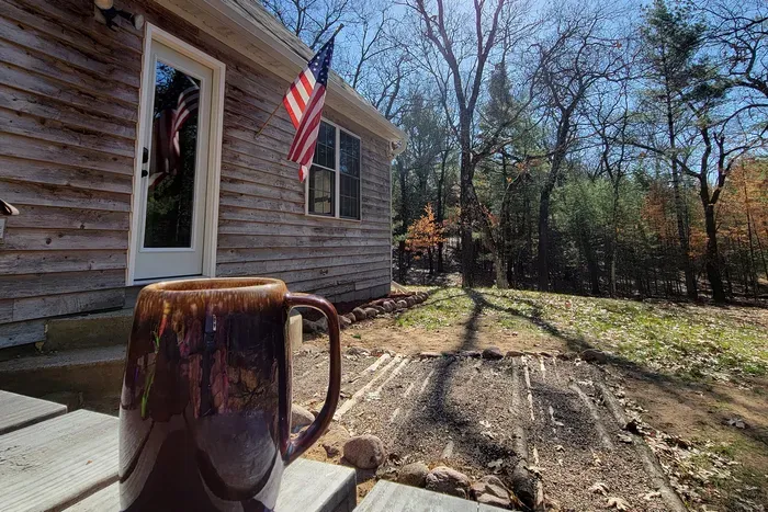 Ease into the day with coffee on the porch, surrounded by sunlit trees and the quiet comfort of a woodland getaway.