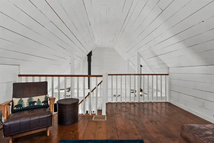 A cozy loft featuring two comfortable beds, perfect for friends or family seeking a private, relaxed sleeping space.