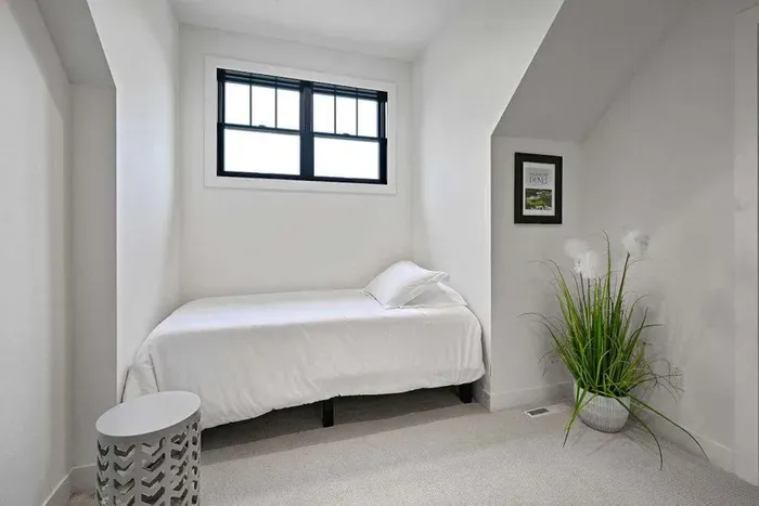 Serene corner bedroom w/ soft textures and simple styling