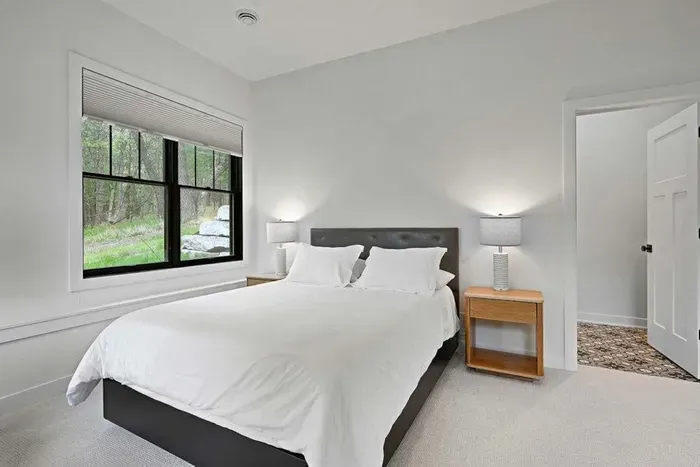 Bright bedroom w/ crisp linens and a calm, uncluttered layout