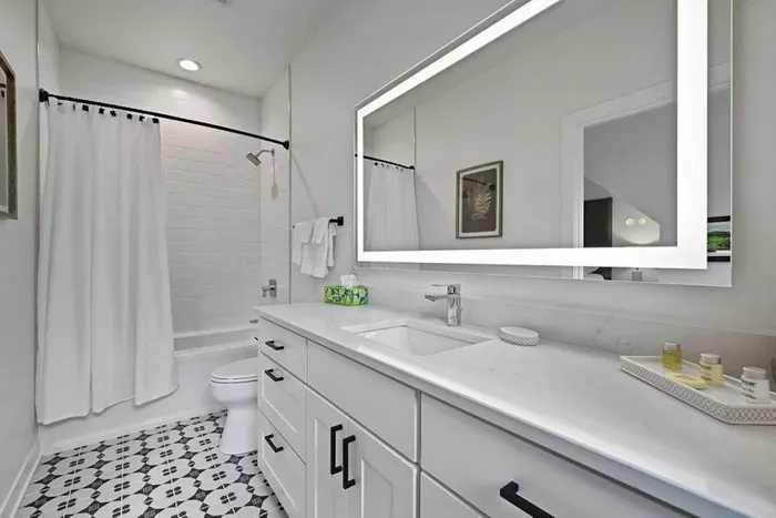 Bright bathroom w/ glass shower and streamlined design