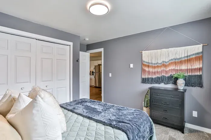 Relaxed sleeping space designed for comfort, with soft finishes, a calming color palette, and practical storage nearby.