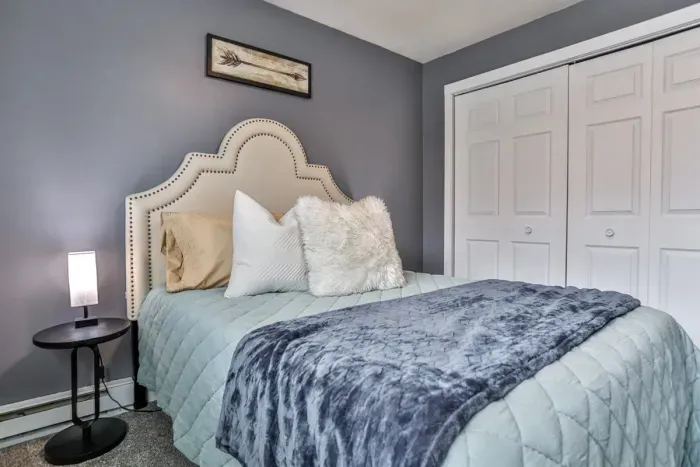 Functional and welcoming bedroom with generous closet access, comfortable proportions, and warm decorative touches.