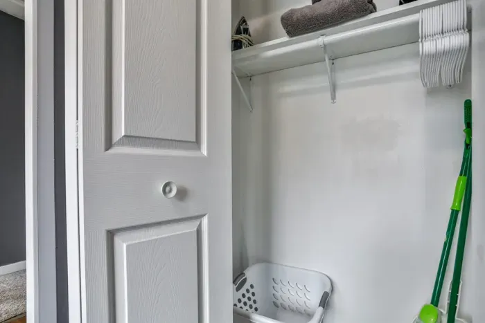 Convenient closet storage with shelving and hanging space, ideal for linens, laundry items, and everyday household essentials.