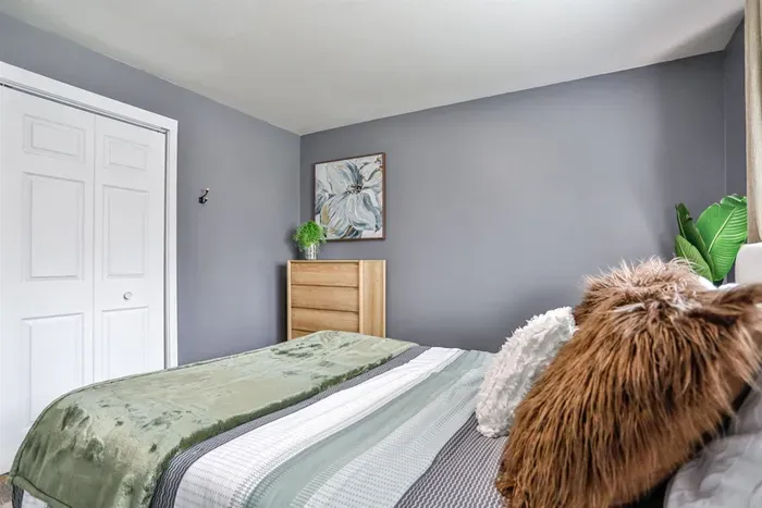 Restful bedroom space featuring a large window, soft lighting, and a soothing color palette that creates a welcoming atmosphere.