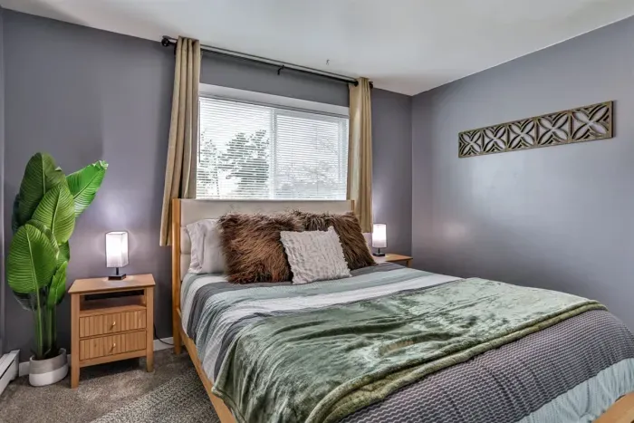 Spacious and cozy sleeping area with soft neutral accents, bedside tables, and a comfortable setup ideal for everyday living.