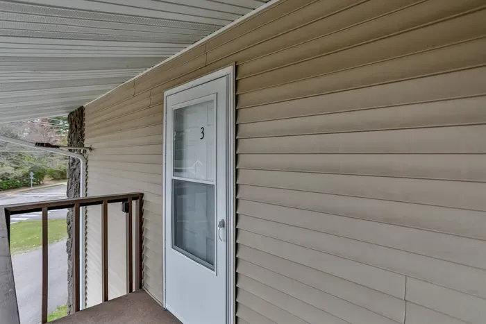 Covered exterior entry with private balcony access, offering a sheltered and welcoming approach to the home.