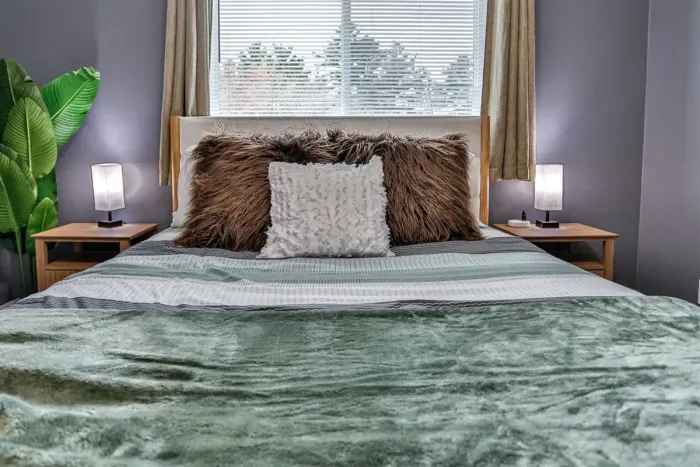 Charming bedroom with modern styling, complete with layered bedding, decorative accents, and comfortable proportions.