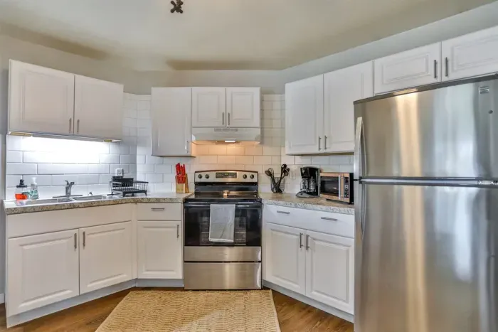 Bright kitchen space with modern appeal, offering stainless appliances, subway-style backsplash, and a cozy eat-in area.