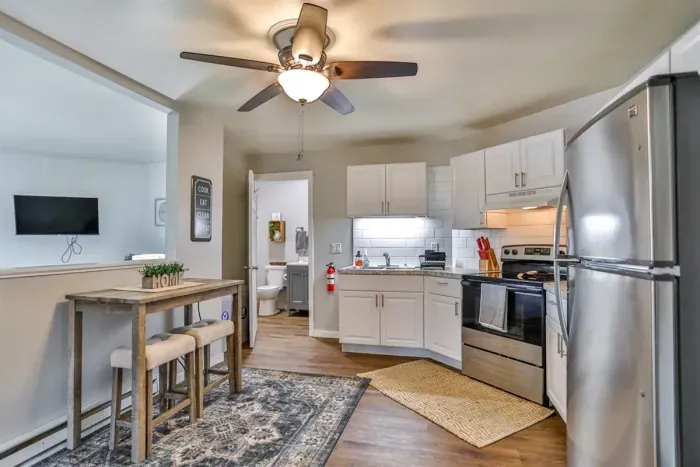 Functional and inviting kitchen featuring white cabinetry, stainless steel appliances, and an adjoining dining nook for casual meals.