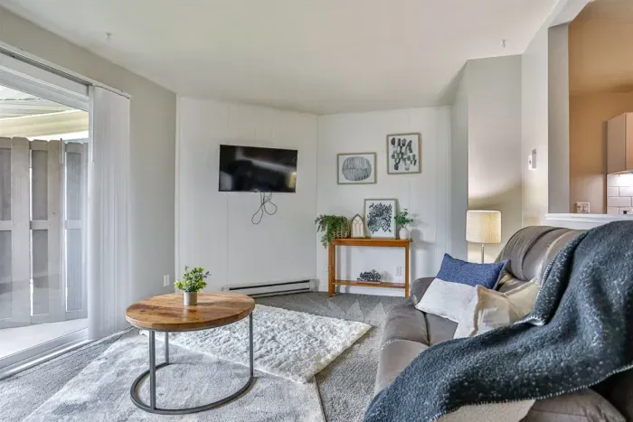 Well-styled living room with a comfortable seating arrangement, accent lighting, and direct access to fresh outdoor space.