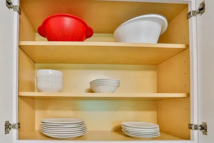 A modern kitchen equipped with high-end appliances and ample lighting. It has a coffee maker, oven, stove top, utensils, and all it takes to fix a delicious meal.