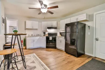 A modern kitchen equipped with high-end appliances and ample lighting. It has a coffee maker, oven, stove top, utensils, and all it takes to fix a delicious meal.