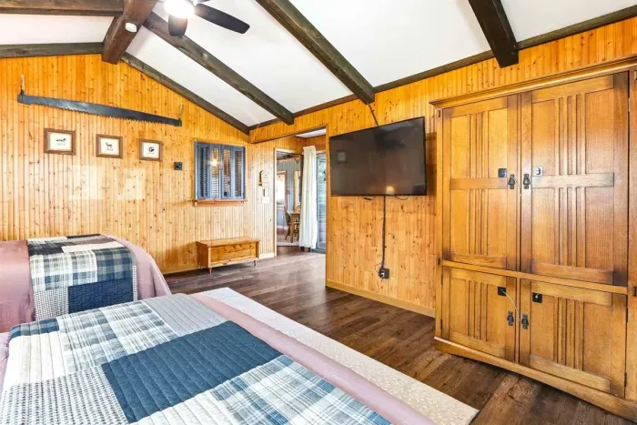 Rustic cabin-style room with 2 comfortable queen beds, large windows, and cozy vibes, ideal for group stays or work trips.