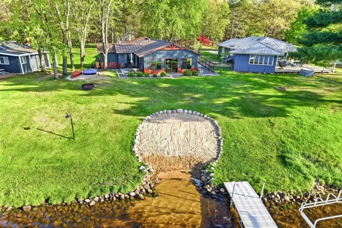 Inviting lakeside retreat featuring sandy beach access, mature trees, and plenty of outdoor space for relaxing or gathering.