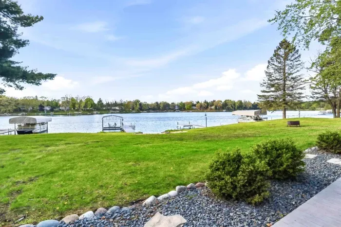 Peaceful lakefront view with open green space, private dock access, and beautiful water views just steps from the cottage.