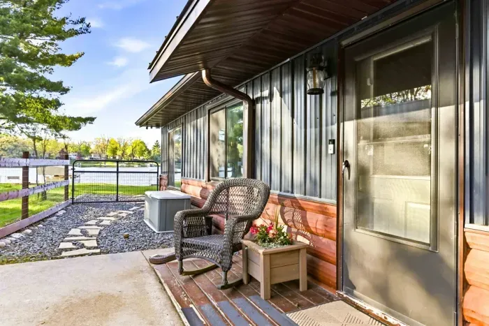 Private lakeside entry with a cozy sitting spot, fenced walkway, and peaceful water views just steps from the door.