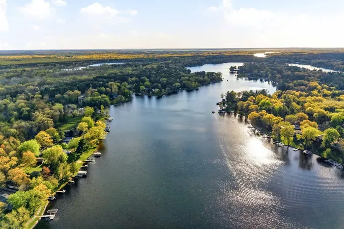 Scenic waterfront setting with wide lake views, mature trees, and a beautiful natural landscape.