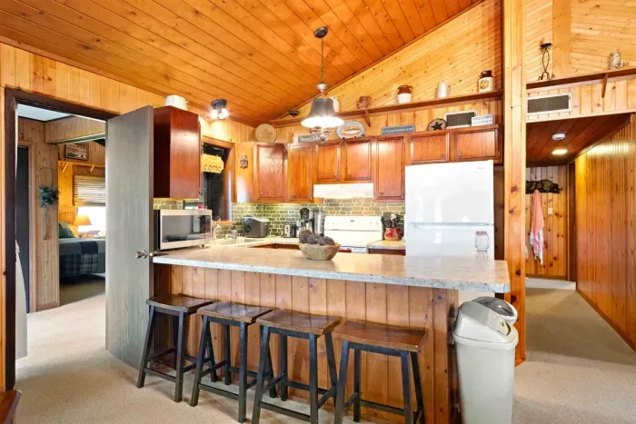 A well-equipped kitchen with modern appliances and a stylish bar stool, perfect for casual meals or morning coffee.