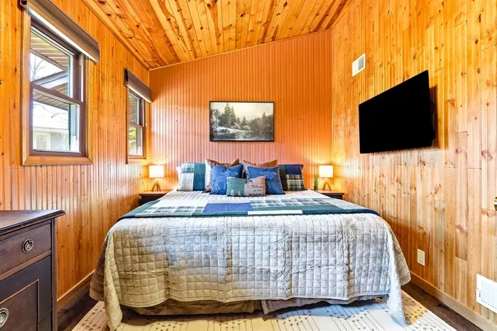 Rustic cabin-style room with comfortable bedding, and cozy vibes, ideal for work trips or weekend stays.
