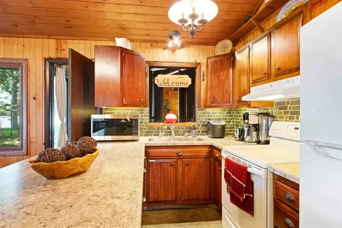 A well-equipped kitchen with modern appliances and a stylish bar stool, perfect for casual meals or morning coffee.