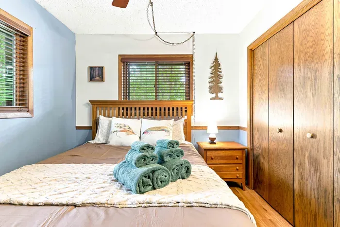 Sink into comfortable bedding on the sturdy wooden bed, complete with a bedside nightstand and lamp for quiet evening reading. An overhead ceiling fan keeps the air fresh and breezy as you drift off to sleep.