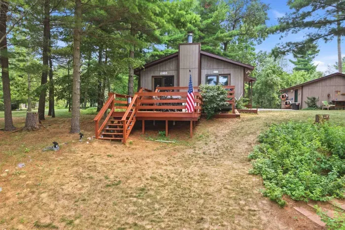 Relax in total privacy at this secluded cabin getaway, featuring a spacious wooden deck for outdoor lounging surrounded by soaring pine trees and a sprawling, natural yard.