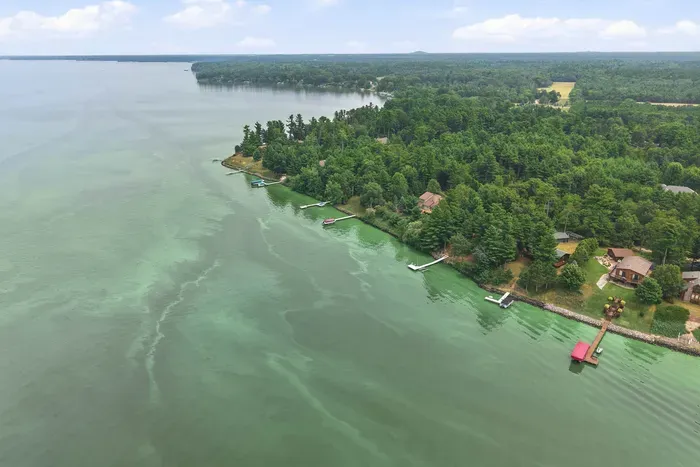 Take in stunning aerial views of the lush shoreline, where pristine forest meets the water and your private boat dock awaits for endless lake adventures.