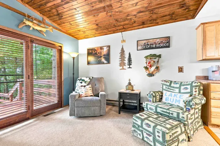 Experience classic cabin comfort in a bright living room made for relaxing after a day on the lake. Stay cool with the ceiling fan, cozy up by the fireplace, or step right through the glass sliding doors to enjoy fresh air and forest views.